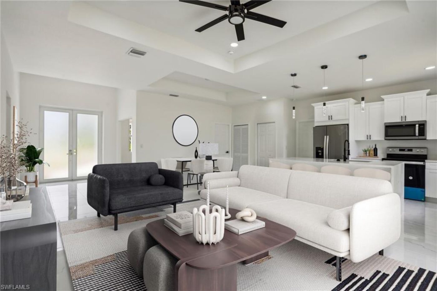 Bright open-concept living room and kitchen with tray ceilings